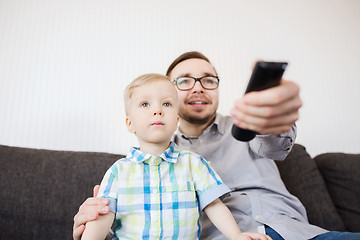 Image showing father and son with remote watching tv at home