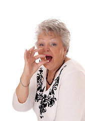 Image showing Senior woman swallowing vitamin pill.