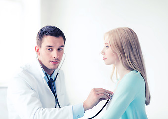 Image showing doctor with stethoscope listening to the patient