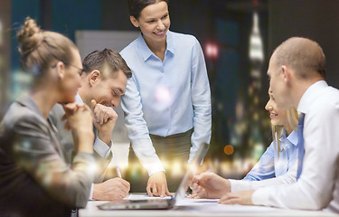 Image showing smiling female boss talking to business team