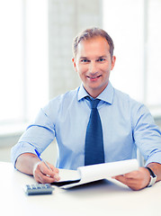 Image showing businessman with notebook and calculator