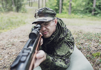 Image showing close up of soldier or hunter with gun in forest