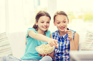 Image showing happy girls with popcorn watching tv at home