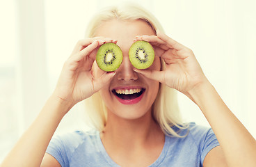 Image showing happy woman having fun covering eyes with kiwi