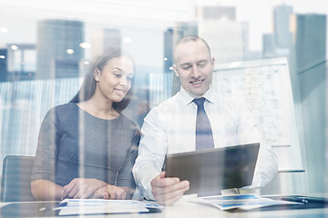 Image showing smiling businesspeople with tablet pc in office