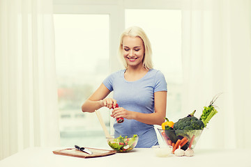 Image showing smiling woman cooking vegetable salad at home