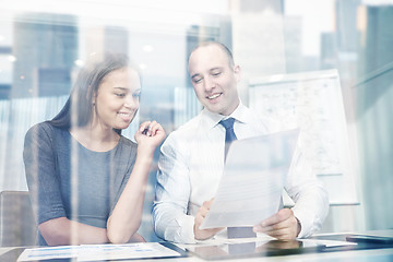 Image showing smiling businesspeople with papers in office