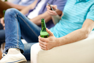 Image showing close up of male friends drinking beer at home