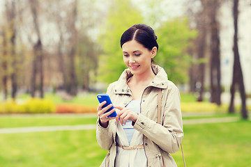 Image showing smiling woman calling on smartphone in park