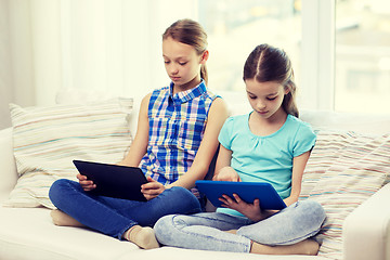 Image showing girls with tablet pc sitting on sofa at home