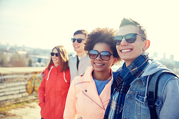 Image showing happy teenage friends in shades hugging on street