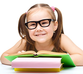 Image showing Little girl is reading a book