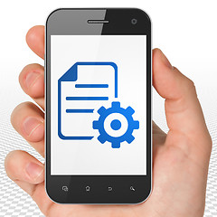 Image showing Database concept: Hand Holding Smartphone with Gear on display