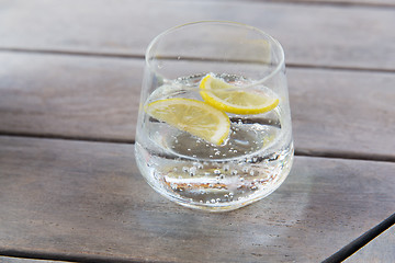 Image showing glass of sparkling water with lemon on table