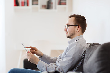 Image showing smiling man working with tablet pc at home