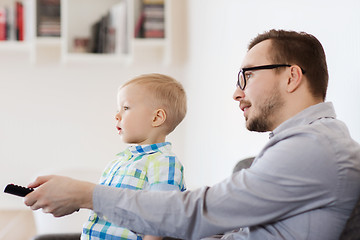 Image showing father and son with remote watching tv at home