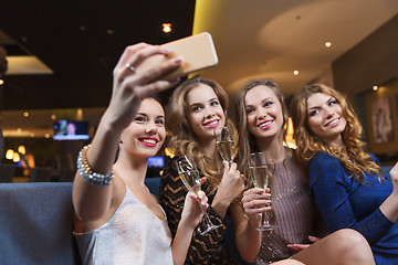 Image showing women with champagne taking selfie at night club