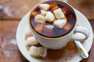 Image showing close up of sugar in coffee cup on wooden table