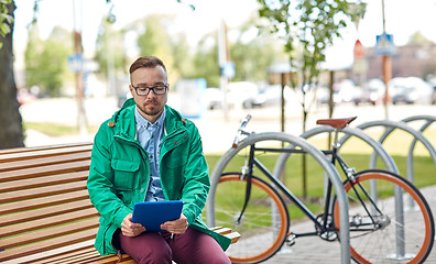 Image showing sad young hipster man with tablet pc and bike