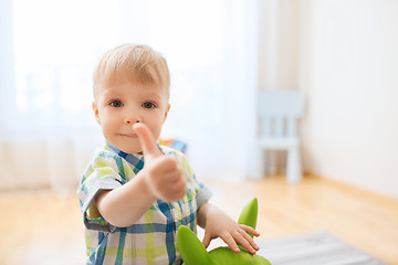 Image showing happy baby boy playing with toy showing thumbs up