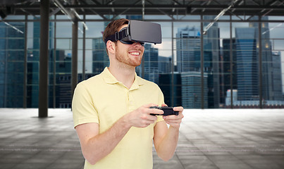 Image showing happy man in virtual reality headset with gamepad