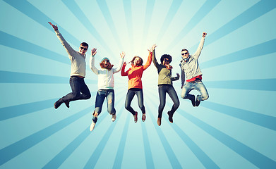 Image showing smiling friends in sunglasses jumping high