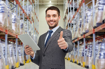 Image showing businessman with tablet pc over warehouse