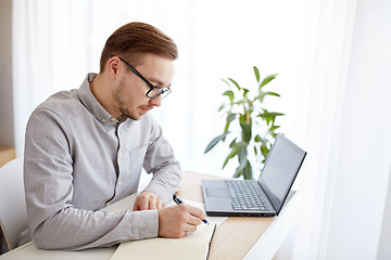 Image showing creative man or businessman writing to notebook