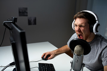 Image showing man in headset playing computer video game at home