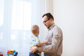 Image showing father taking care of little son at home