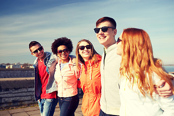 Image showing happy teenage friends walking along city street