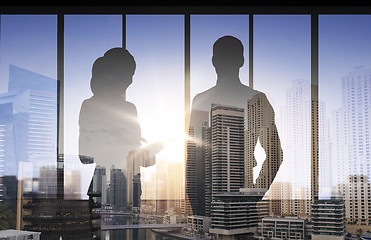 Image showing silhouettes of business partners over city office