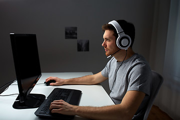 Image showing man in headset playing computer video game at home