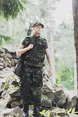 Image showing young soldier or hunter with gun in forest