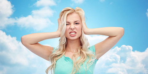 Image showing young woman holding to her head and screaming