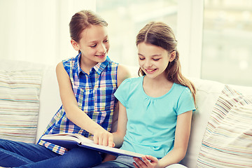 Image showing two happy girls reading book at home