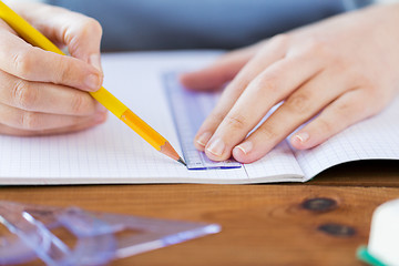 Image showing close up of hands with ruler and pencil drawing 