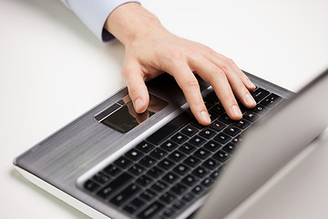 Image showing close up of businessman hand typing on laptop