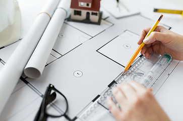 Image showing close up of hands with ruler measuring blueprint