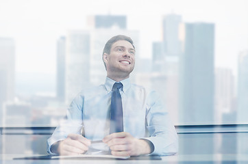 Image showing smiling businessman sitting in office