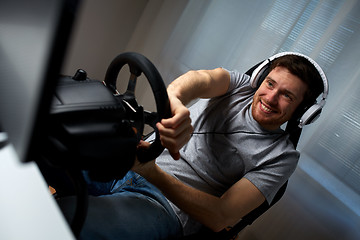 Image showing man playing car racing video game at home