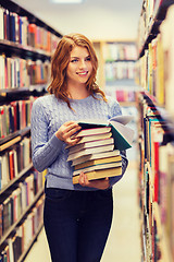 Image showing happy student girl or woman with books in library