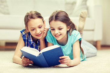 Image showing two happy girls reading book at home