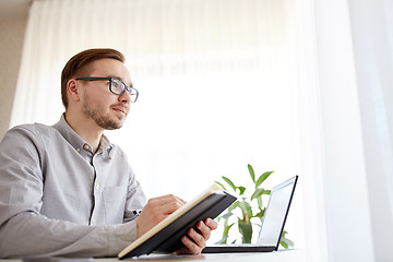 Image showing creative male worker or businessman with notebook