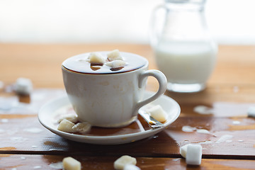 Image showing close up of sugar in coffee cup on wooden table