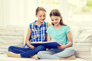 Image showing two happy girls reading book at home