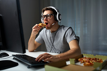 Image showing man in headset playing computer video game at home