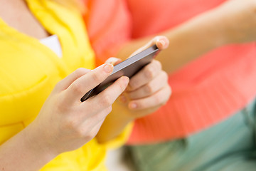 Image showing close up of woman texting on smartphone at home