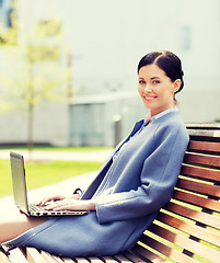 Image showing smiling business woman with laptop in city