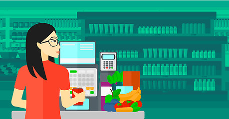 Image showing Cashier at supermarket checkout.